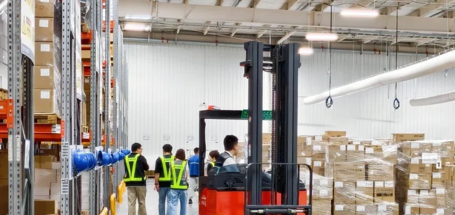 Receiving team and pallet handling beside stacked cartons