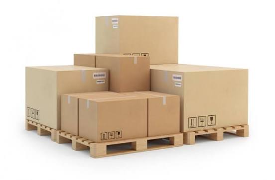 A stack of various-sized cardboard boxes with shipping labels and handling symbols, arranged on wooden pallets against a white background.